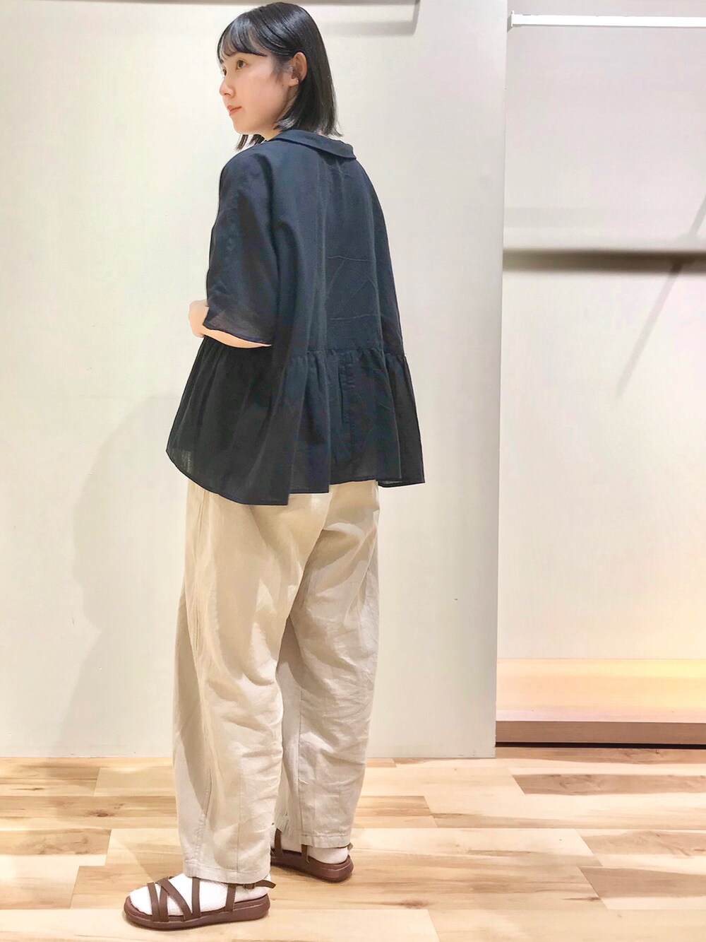 ブラック系のシャツ/ブラウス、ベージュ系のその他パンツ、イエロー系のサンダルを着用したレディースの夏コーディネートの2枚目の写真