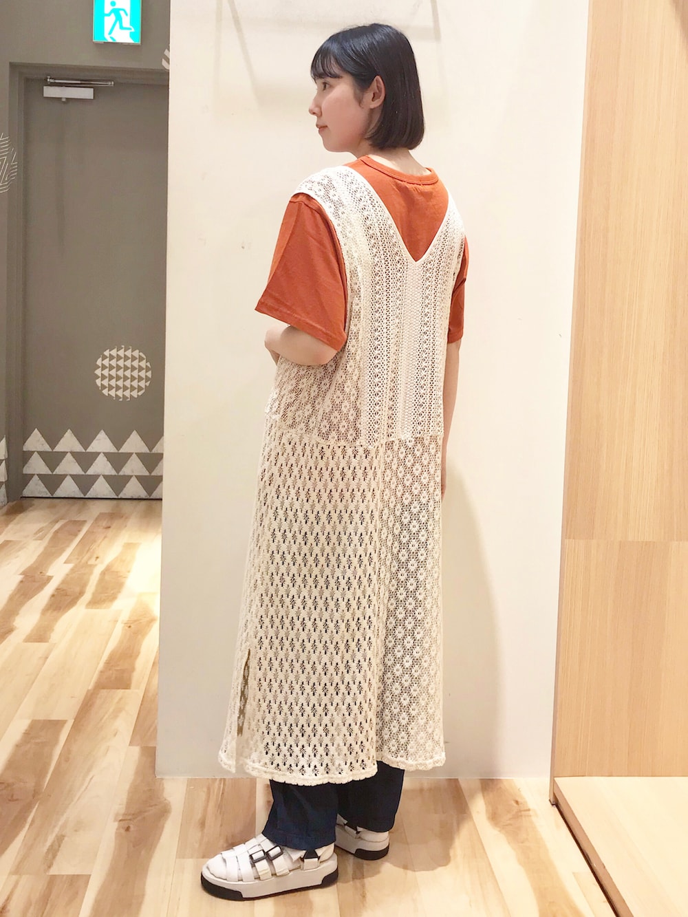 ホワイト系のワンピース、ブルー系のデニムパンツ、ホワイト系のサンダルを着用したレディースの夏コーディネートの2枚目の写真