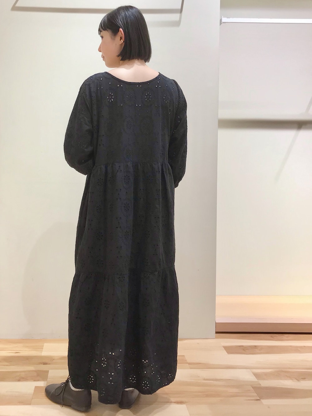ブラック系のワンピース、ベージュ系のハンドバッグ、ブラウン系のその他シューズを着用したレディースの夏コーディネートの2枚目の写真