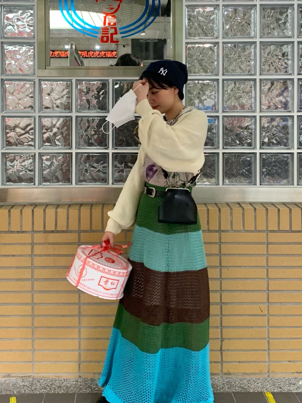 ベージュ系のカーディガン/ボレロ、グレー系のTシャツ/カットソー、ブラック系のショルダーバッグを着用したレディースの春コーディネートの2枚目の写真