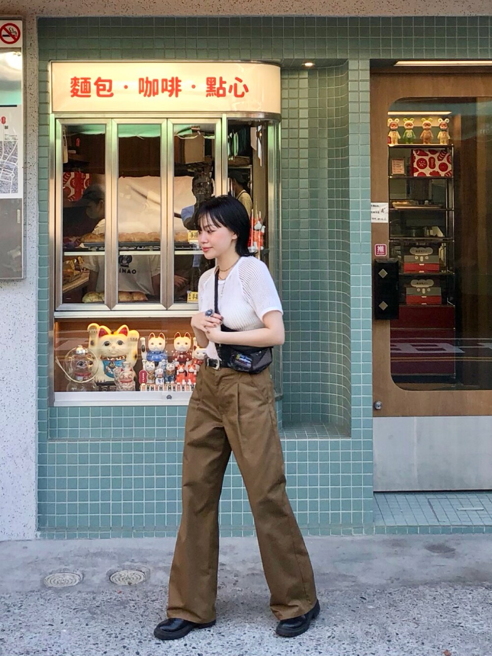 ブラウン系のチノパンツ、ブラック系のブーツ、ホワイト系のTシャツ/カットソーを着用したレディースの春コーディネートの2枚目の写真