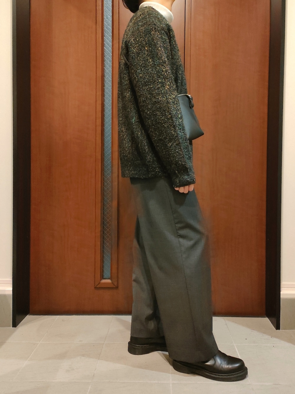 グレー系のニット/セーター、グリーン系のカーディガン/ボレロ、ブラック系のショルダーバッグを着用したメンズの冬コーディネートの2枚目の写真