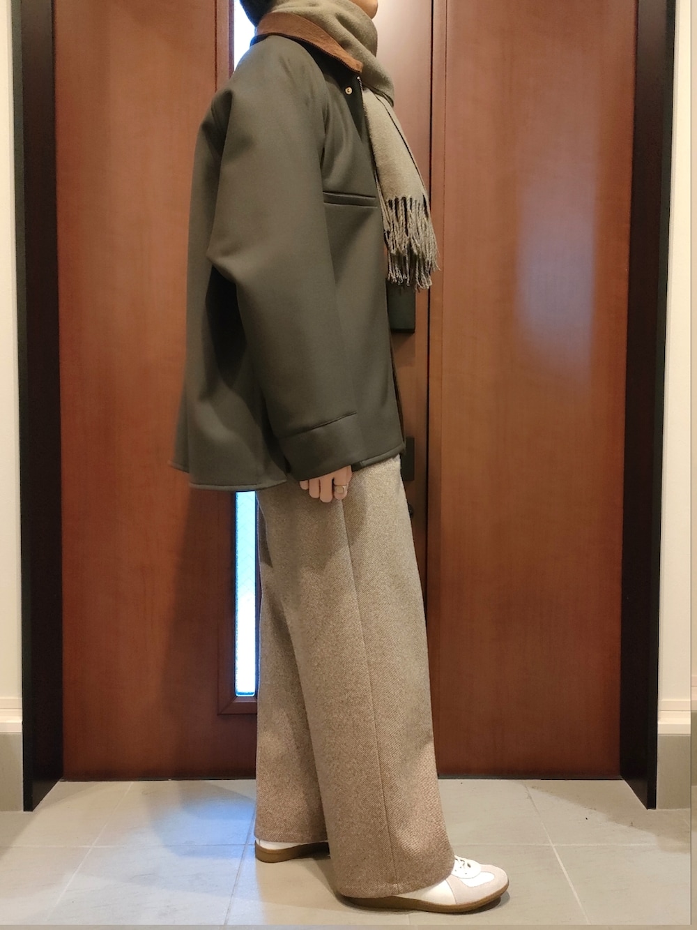 ブラウン系のニット/セーター、グリーン系のその他アウター、ベージュ系のスラックスを着用したメンズの冬コーディネートの2枚目の写真