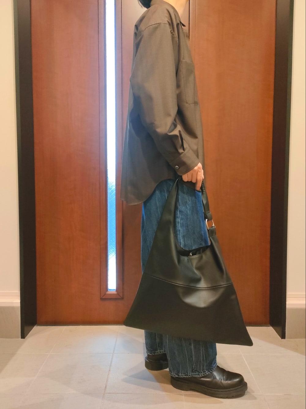 ブラウン系のシャツ/ブラウス、ブルー系のデニムパンツ、ブラック系のブーツを着用したメンズの春コーディネートの2枚目の写真