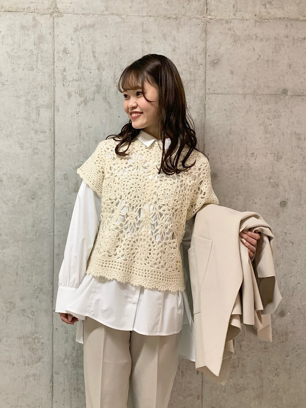 ホワイト系のニット/セーター、ベージュ系のスラックス、ホワイト系のブーツを着用したレディースの冬コーディネートの2枚目の写真