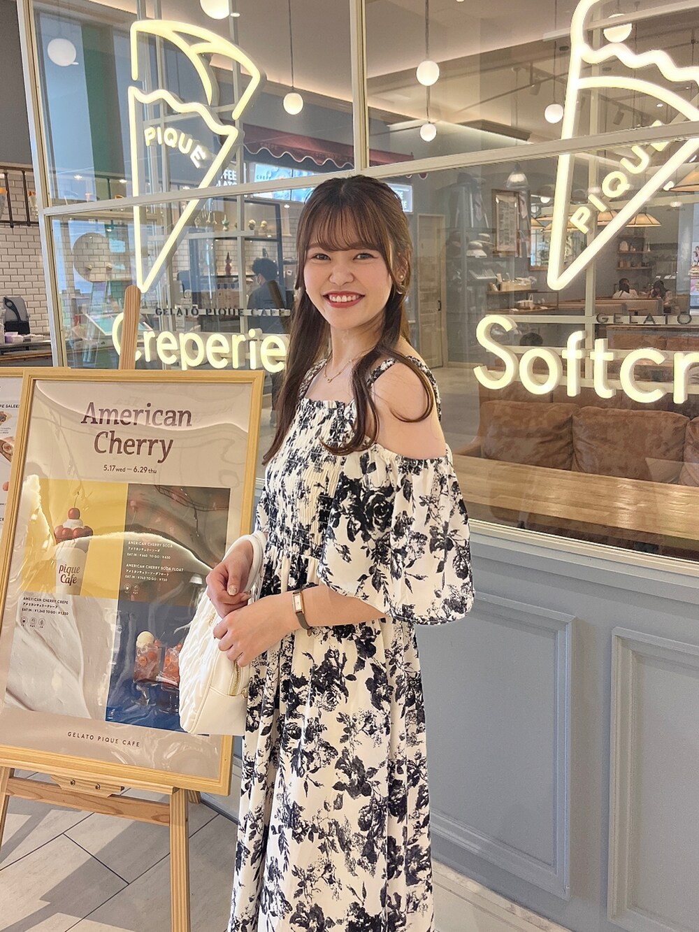 ホワイト系のワンピース、ピンク系のボストンバッグ、ブラック系のサンダルを着用したレディースの夏コーディネートの2枚目の写真