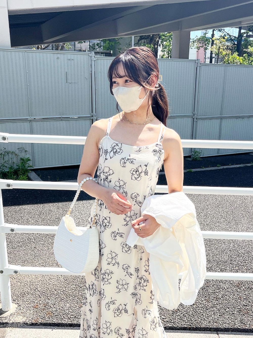 ホワイト系のワンピース、ホワイト系のマウンテンパーカー、ホワイト系のサンダルを着用したレディースの春コーディネートの3枚目の写真