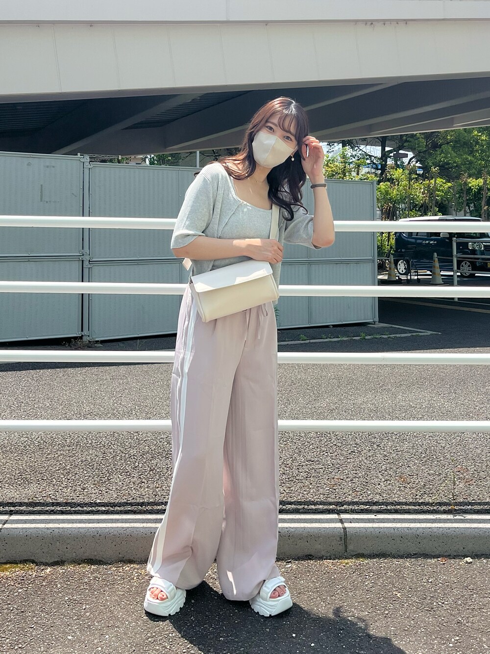 ピンク系のスラックス、ホワイト系のアンサンブル、ホワイト系のボディバッグ/ウエストポーチを着用したレディースの春コーディネートの3枚目の写真