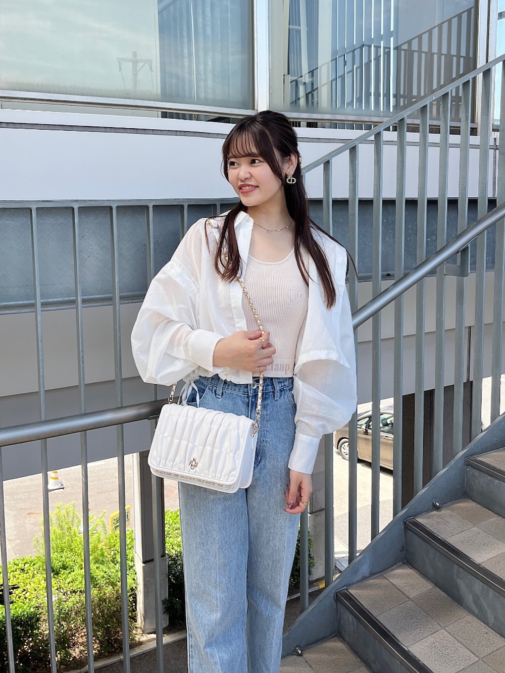 ブルー系のデニムパンツ、ホワイト系のショルダーバッグ、ホワイト系のマウンテンパーカーを着用したレディースの夏コーディネートの2枚目の写真