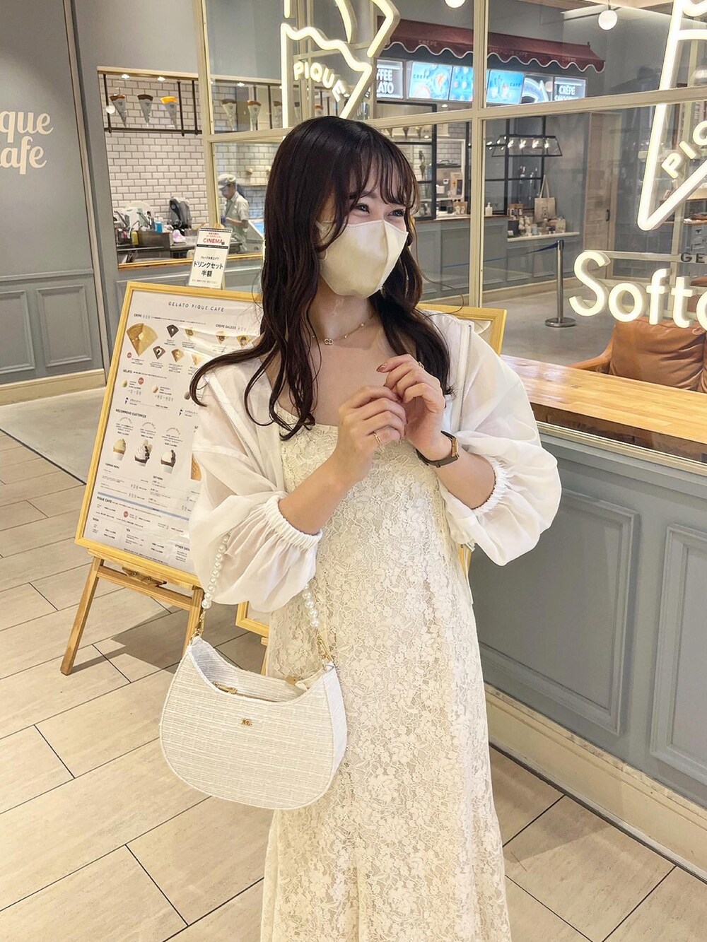 ホワイト系のワンピース、ホワイト系のショルダーバッグ、ホワイト系のマウンテンパーカーを着用したレディースの春コーディネートの3枚目の写真