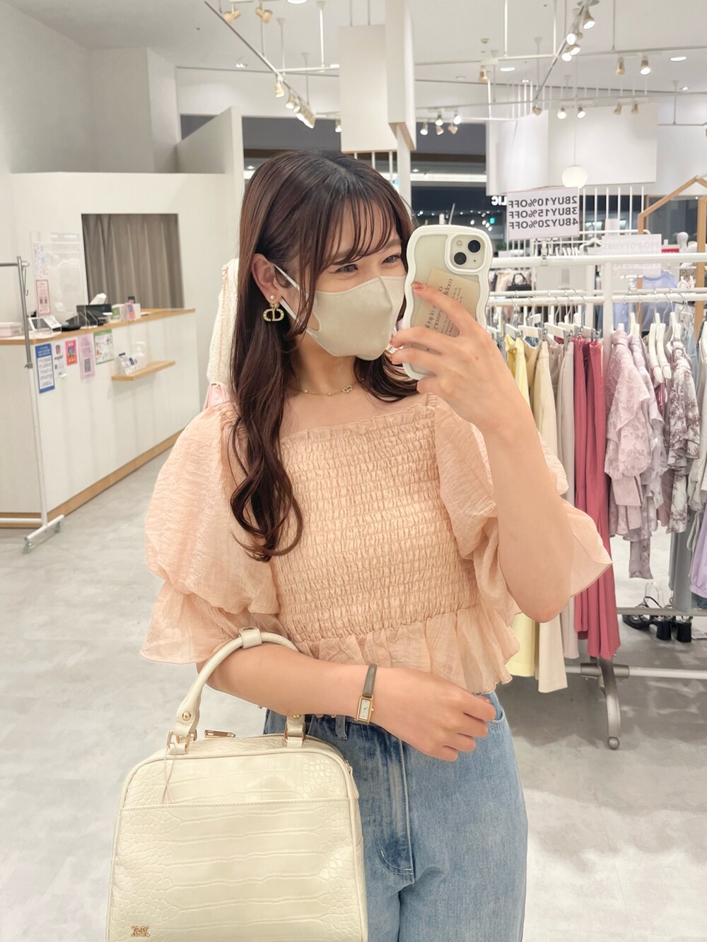 ホワイト系のボストンバッグ、ブルー系のデニムパンツ、ピンク系のシャツ/ブラウスを着用したレディースの夏コーディネートの3枚目の写真