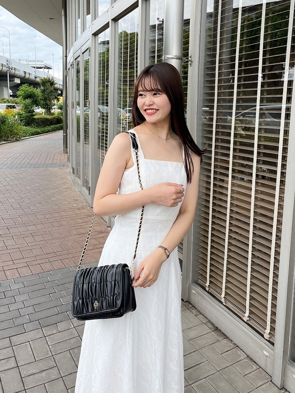 ホワイト系のワンピース、ホワイト系のショルダーバッグ、ホワイト系のサンダルを着用したレディースの春コーディネートの2枚目の写真