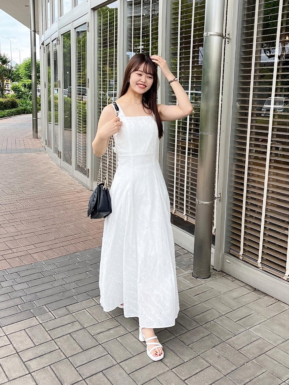 ホワイト系のワンピース、ホワイト系のショルダーバッグ、ホワイト系のサンダルを着用したレディースの夏コーディネートの2枚目の写真