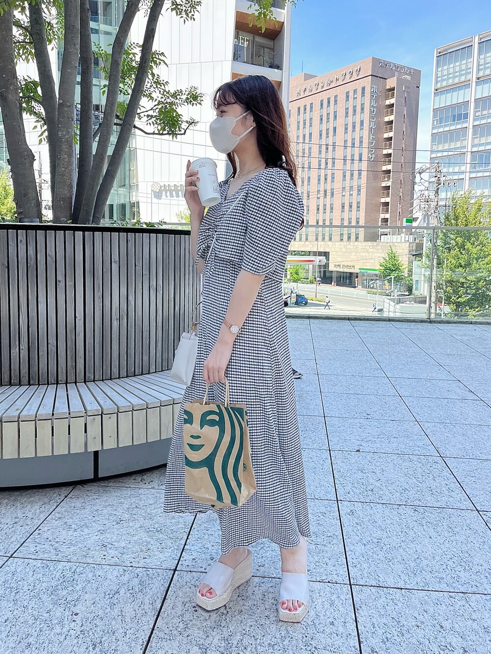 ブラック系のワンピース、ホワイト系のショルダーバッグ、ホワイト系のサンダルを着用したレディースの夏コーディネートの2枚目の写真