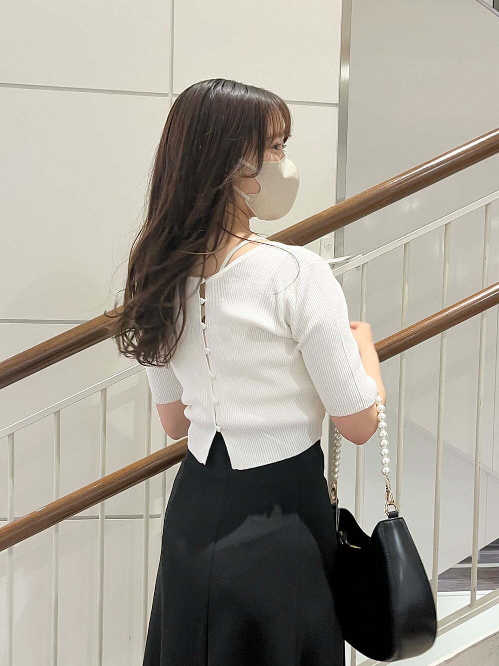 ホワイト系のアンサンブル、ブラック系のスカート、ホワイト系のショルダーバッグを着用したレディースの春コーディネートの3枚目の写真