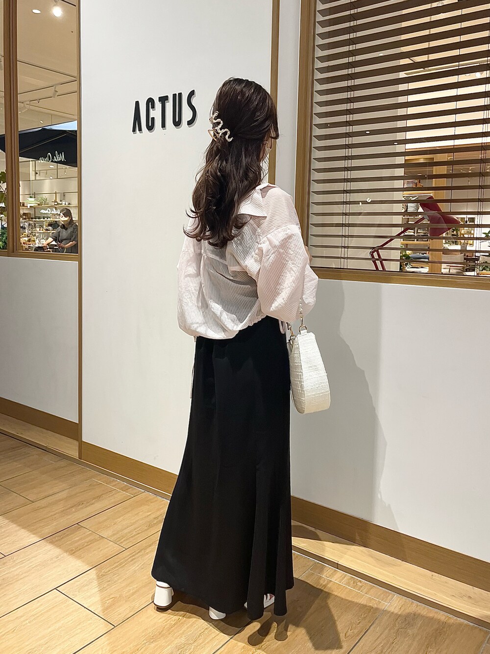 ブラック系のワンピース、ホワイト系のサンダル、ホワイト系のショルダーバッグを着用したレディースの春コーディネートの2枚目の写真