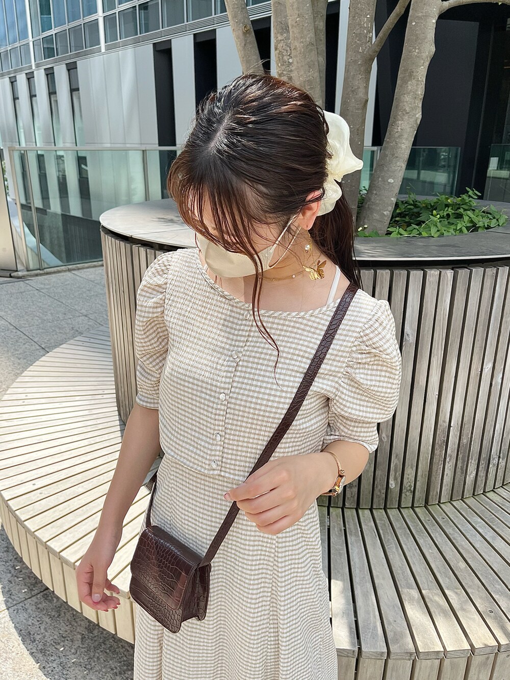 ベージュ系のワンピース、ホワイト系のサンダル、ブラウン系のショルダーバッグを着用したレディースの夏コーディネートの2枚目の写真