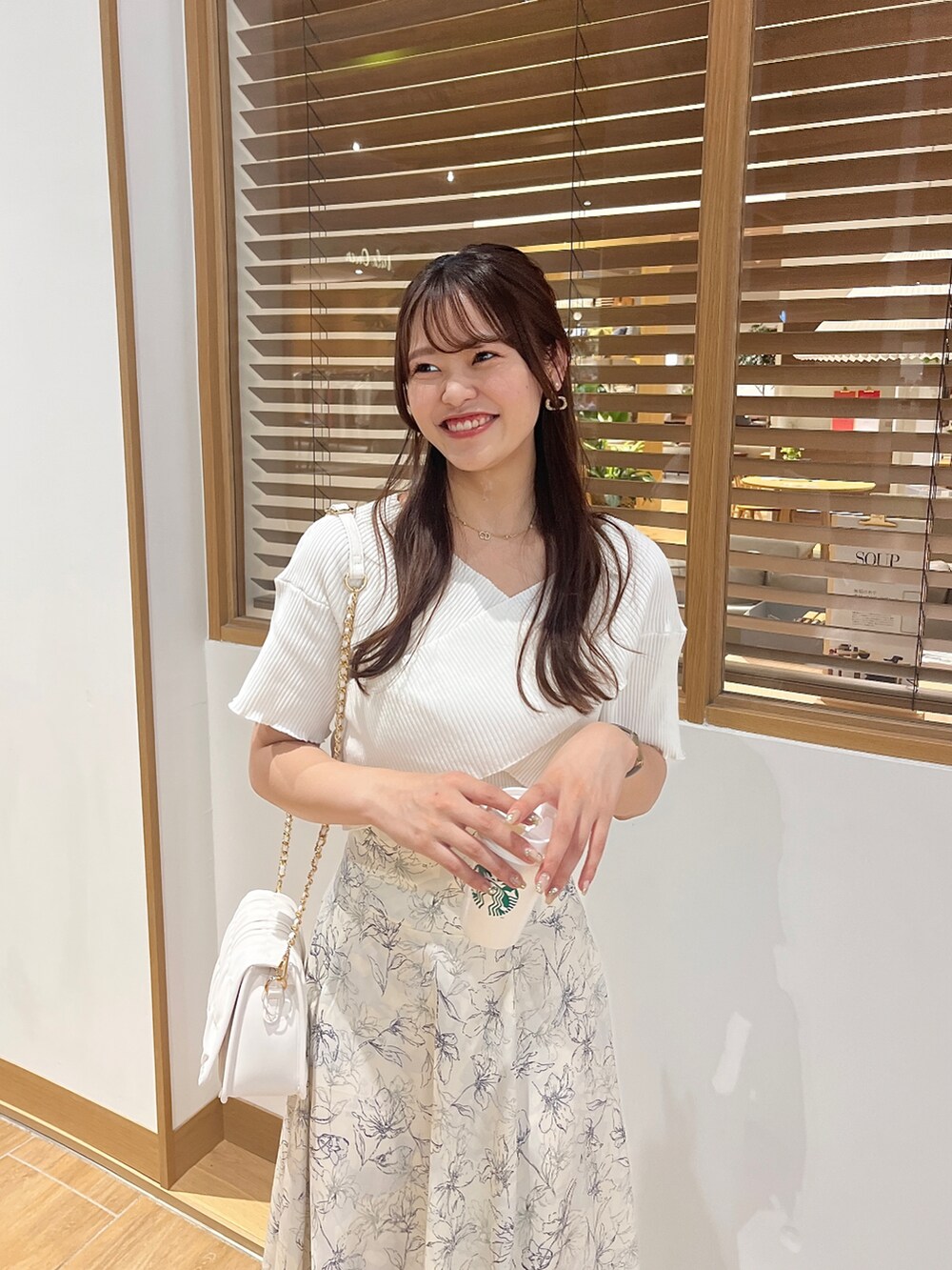 ホワイト系のニット/セーター、その他のスカート、ホワイト系のショルダーバッグを着用したレディースの夏コーディネートの2枚目の写真