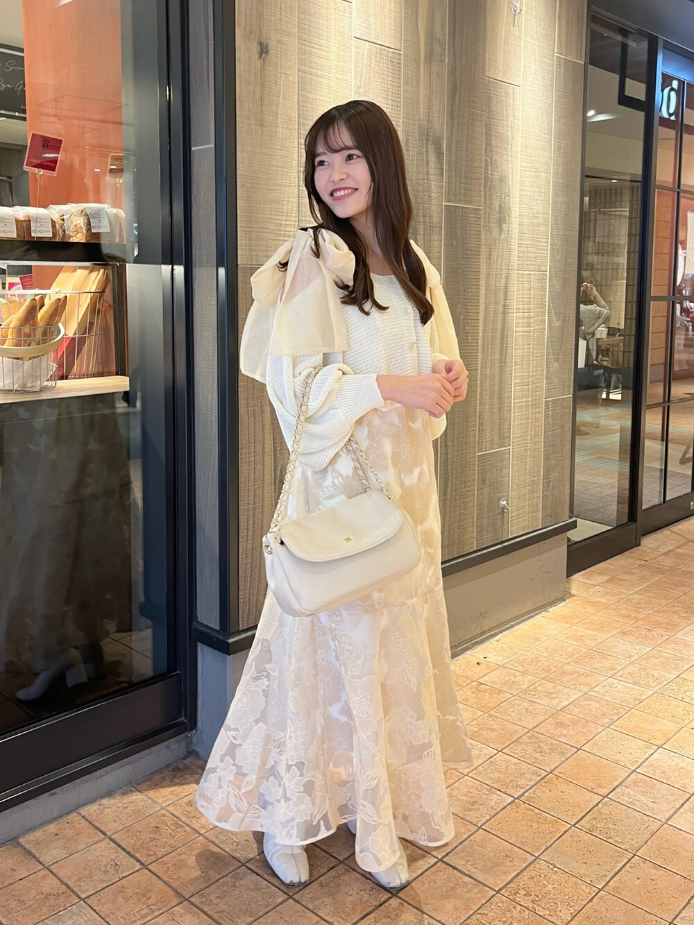 ベージュ系のショルダーバッグ、ホワイト系のワンピースを着用したレディースの春コーディネートの3枚目の写真