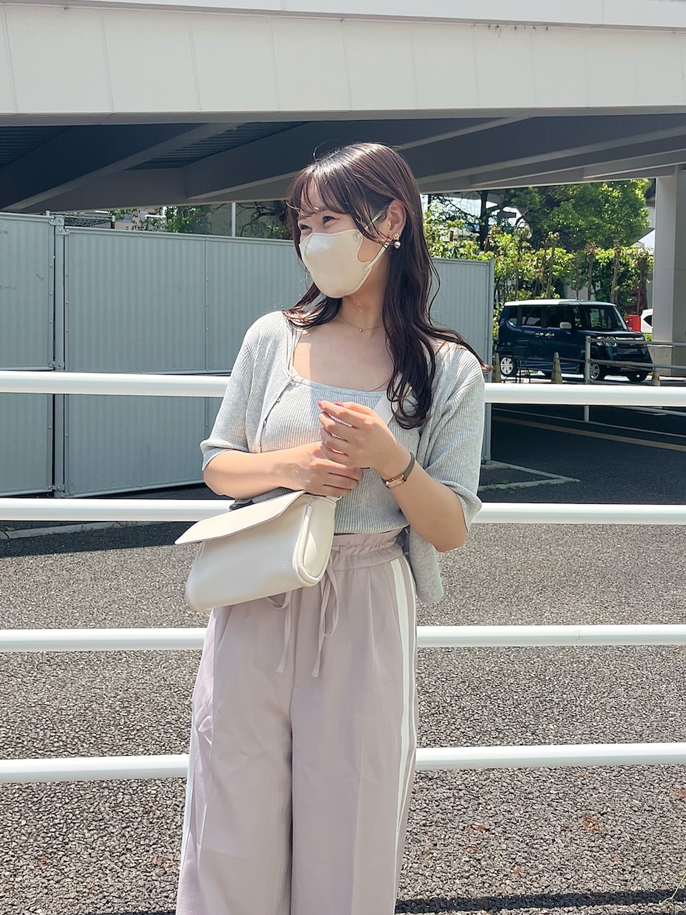 ピンク系のスラックス、ホワイト系のアンサンブル、ホワイト系のボディバッグ/ウエストポーチを着用したレディースの春コーディネートの2枚目の写真