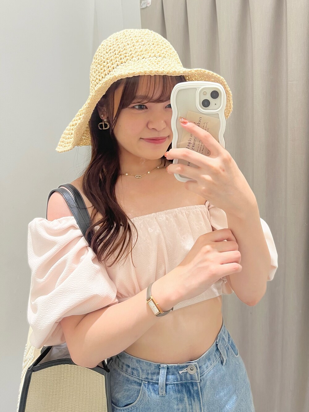 ブルー系のデニムパンツ、ホワイト系のサンダル、ブラック系のトートバッグを着用したレディースの夏コーディネートの2枚目の写真