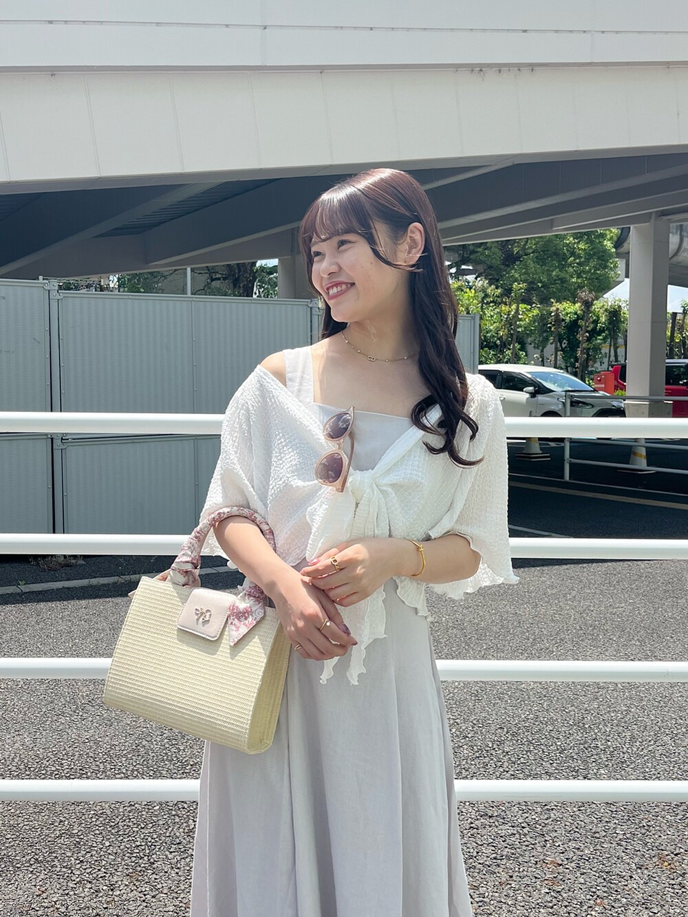 ピンク系のショルダーバッグ、ホワイト系のワンピース、ホワイト系のサンダルを着用したレディースの春コーディネートの2枚目の写真