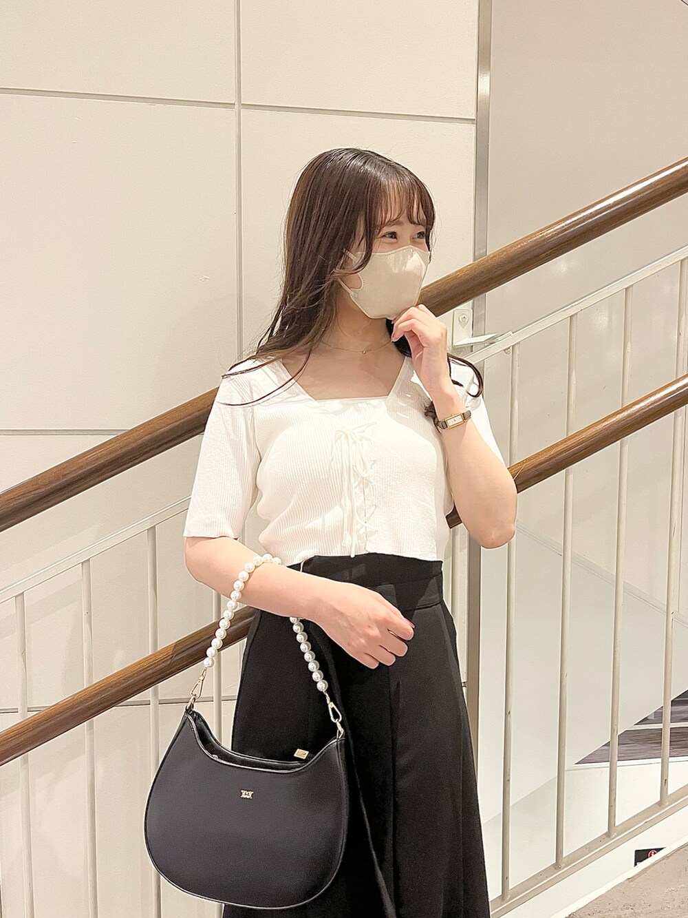 ホワイト系のアンサンブル、ブラック系のスカート、ホワイト系のショルダーバッグを着用したレディースの春コーディネートの2枚目の写真