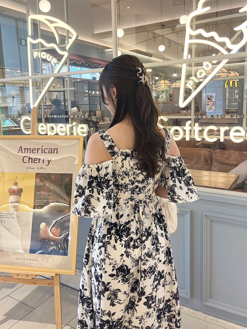 ホワイト系のワンピース、ピンク系のボストンバッグ、ブラック系のサンダルを着用したレディースの夏コーディネートの3枚目の写真