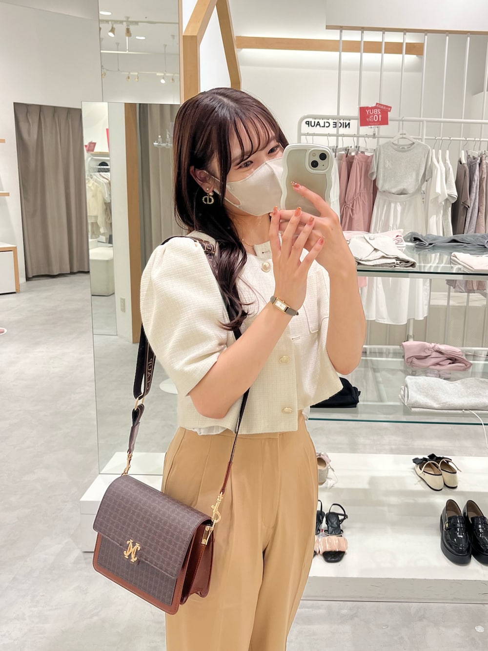 ホワイト系のショルダーバッグ、ピンク系のノーカラージャケット、ベージュ系のスラックスを着用したレディースの夏コーディネートの2枚目の写真