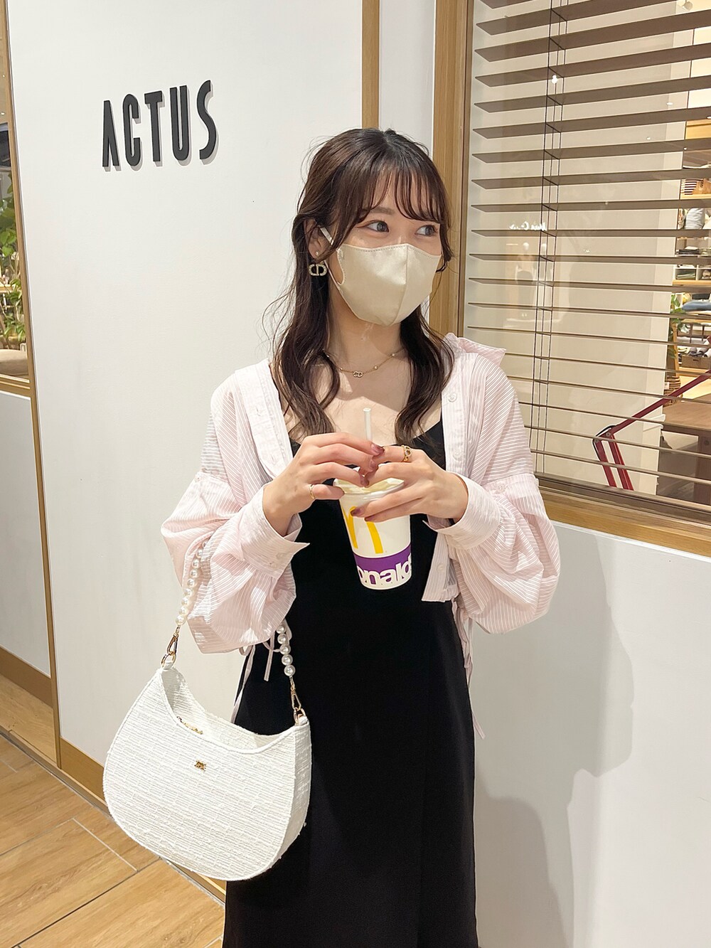 ブラック系のワンピース、ホワイト系のサンダル、ホワイト系のショルダーバッグを着用したレディースの春コーディネートの3枚目の写真