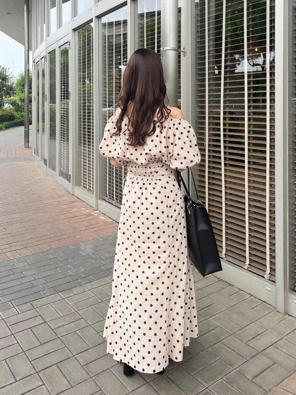 ホワイト系のトートバッグ、ブラック系のサンダル、その他のスカートを着用したレディースの夏コーディネートの3枚目の写真