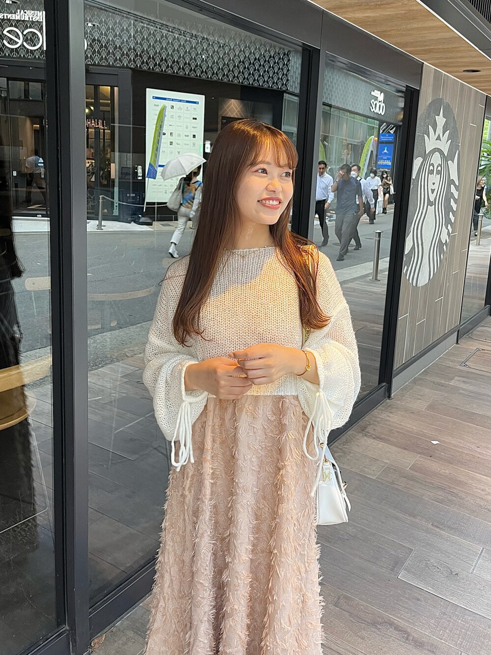 ホワイト系のサンダル、ピンク系のワンピース、ホワイト系のニット/セーターを着用したレディースの夏コーディネートの2枚目の写真