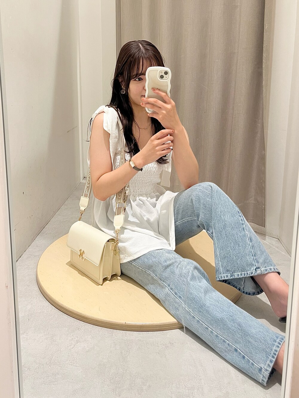 ホワイト系のキャミソール、ブルー系のデニムパンツ、ホワイト系のショルダーバッグを着用したレディースの夏コーディネートの2枚目の写真