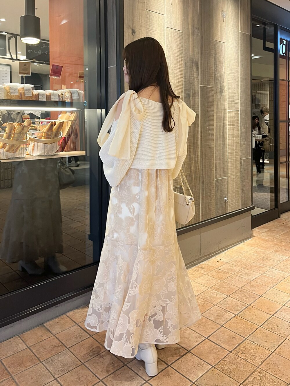 ベージュ系のショルダーバッグ、ホワイト系のワンピースを着用したレディースの春コーディネートの4枚目の写真