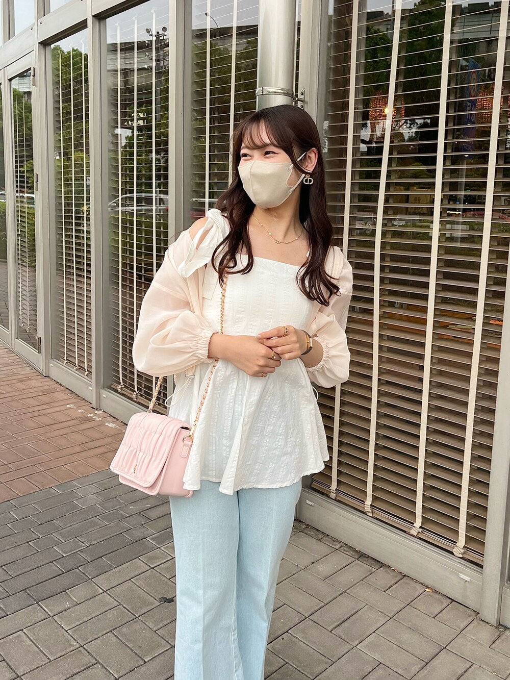 ブルー系のデニムパンツ、ホワイト系のショルダーバッグ、ホワイト系のマウンテンパーカーを着用したレディースの夏コーディネートの2枚目の写真