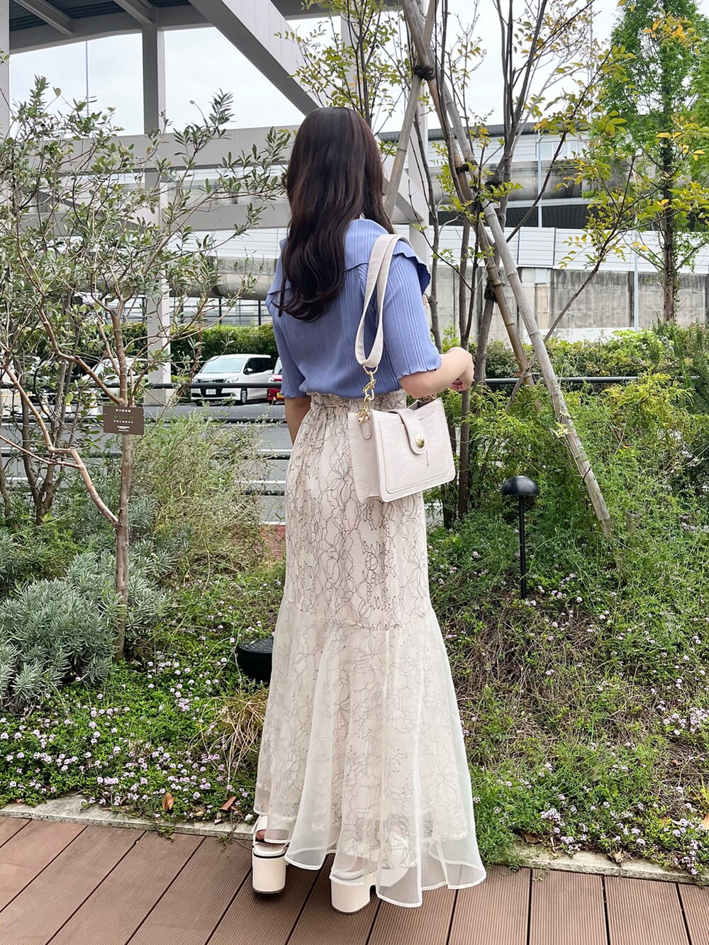 ホワイト系のスカート、ブルー系のTシャツ/カットソー、ホワイト系のサンダルを着用したレディースの春コーディネートの3枚目の写真