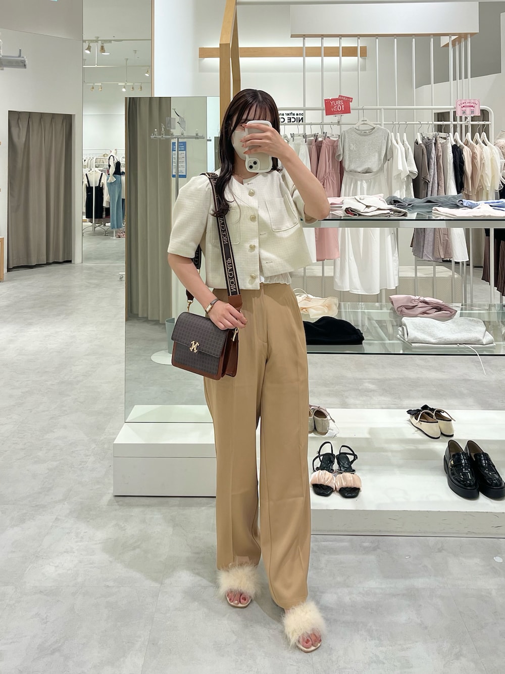 ホワイト系のショルダーバッグ、ピンク系のノーカラージャケット、ベージュ系のスラックスを着用したレディースの夏コーディネートの3枚目の写真