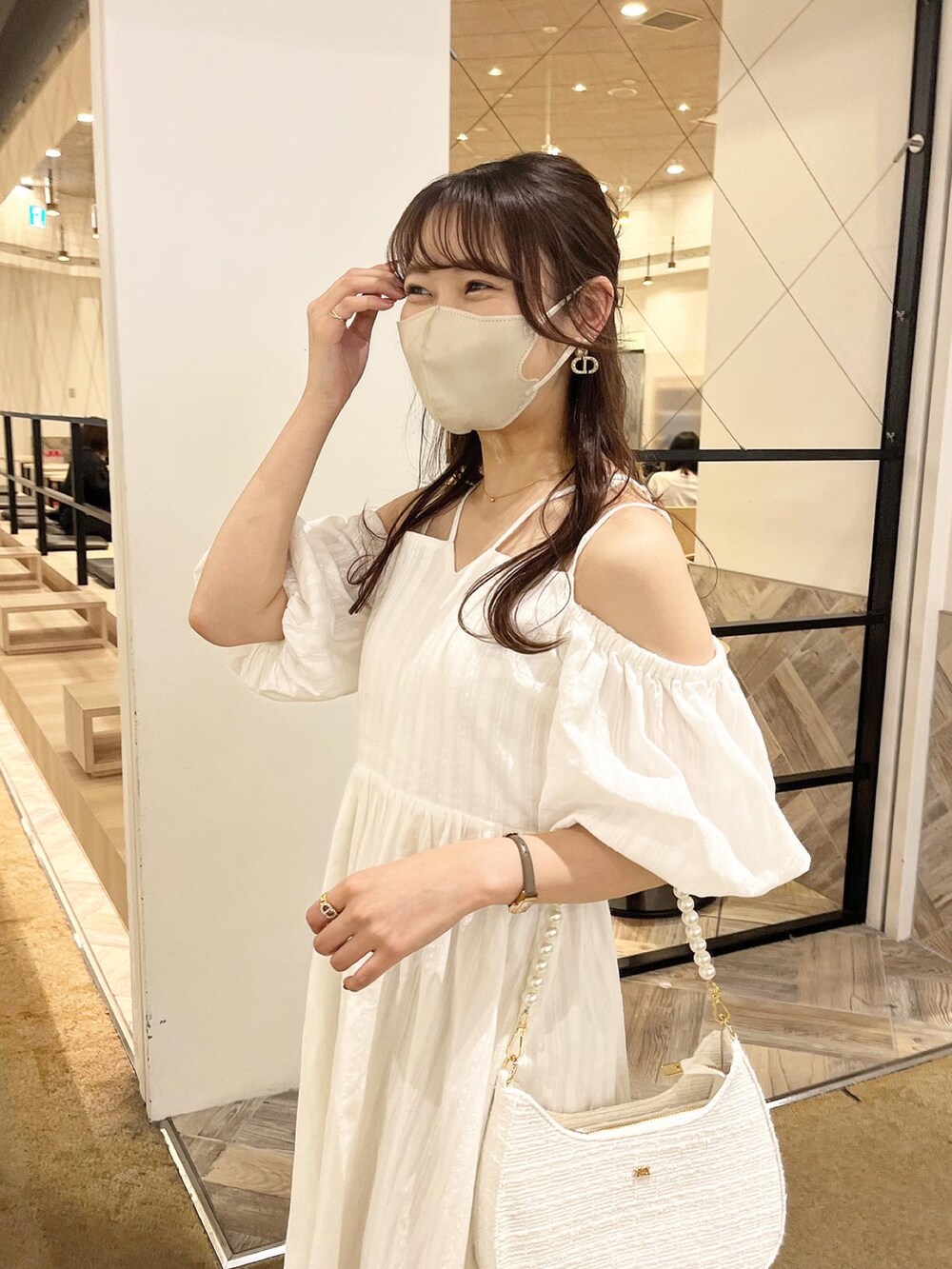 ホワイト系のショルダーバッグ、ホワイト系のワンピース、ホワイト系のサンダルを着用したレディースの春コーディネートの2枚目の写真