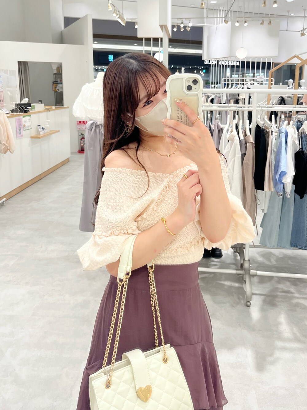 ホワイト系のサンダル、ホワイト系のショルダーバッグ、ブラウン系のスカートを着用したレディースの夏コーディネートの2枚目の写真