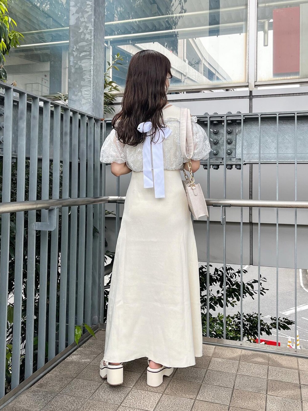 ホワイト系のワンピース、ホワイト系のショルダーバッグ、ホワイト系のサンダルを着用したレディースの春コーディネートの3枚目の写真