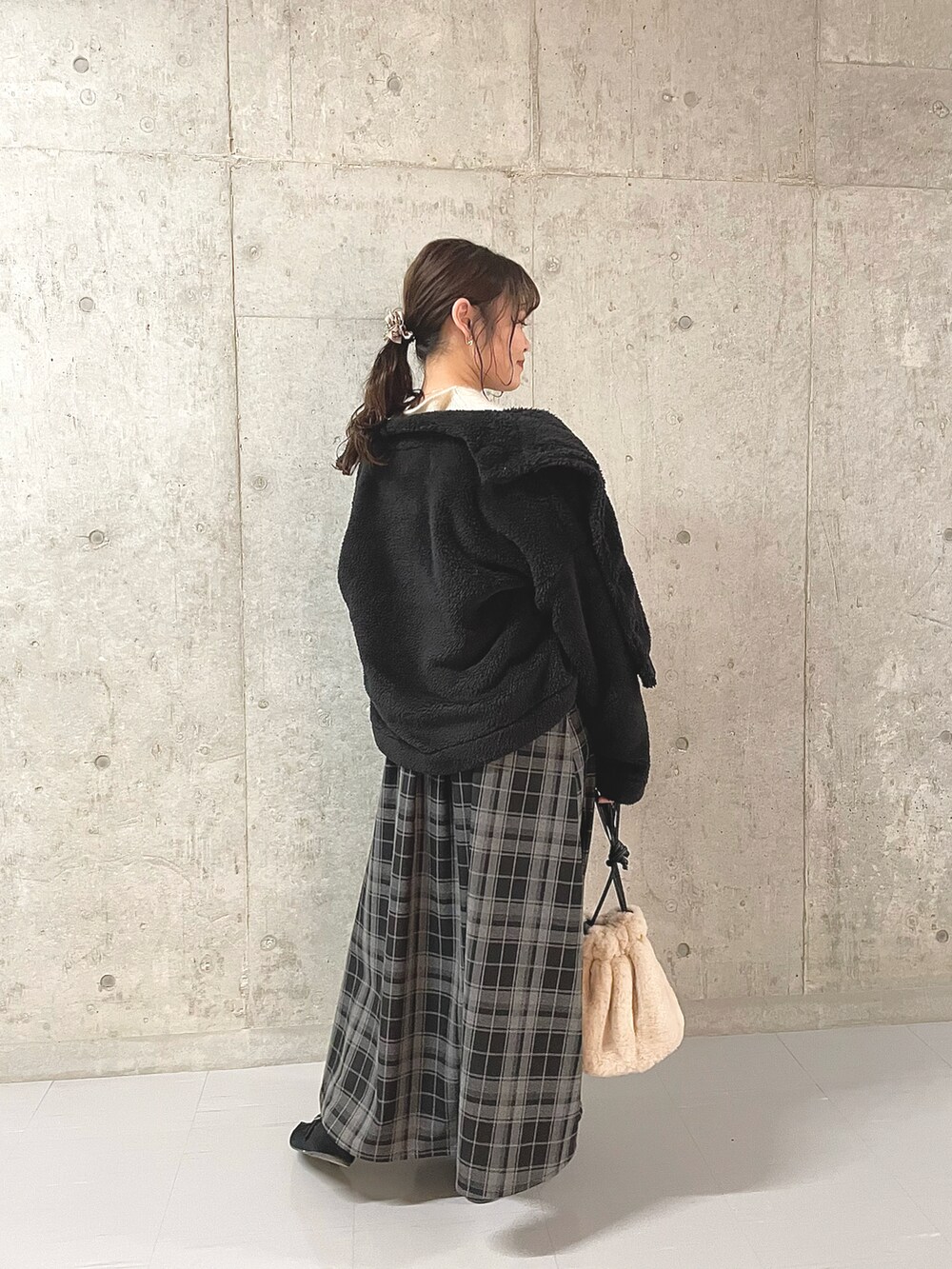 ホワイト系のニット/セーター、ブラック系のその他アウター、ブラック系のスカートを着用したレディースの冬コーディネートの2枚目の写真