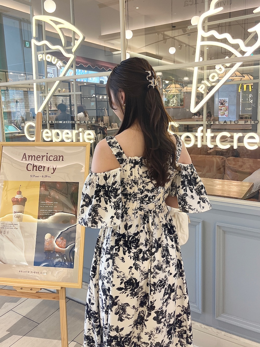 ピンク系のボストンバッグ、ホワイト系のワンピース、ブラック系のサンダルを着用したレディースの夏コーディネートの2枚目の写真