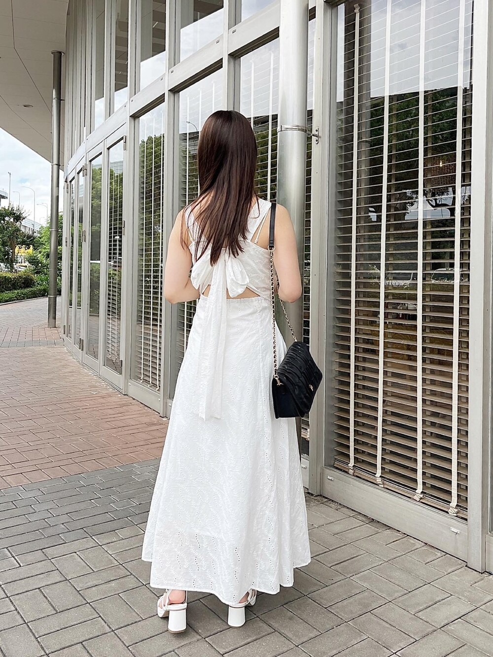 ホワイト系のワンピース、ホワイト系のショルダーバッグ、ホワイト系のサンダルを着用したレディースの夏コーディネートの3枚目の写真