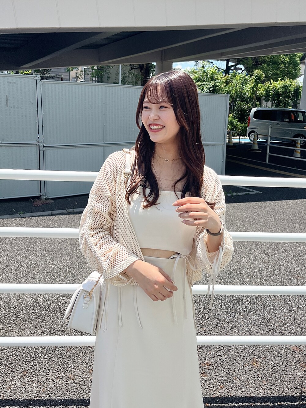 ホワイト系のワンピース、ホワイト系のサンダル、ホワイト系のショルダーバッグを着用したレディースの夏コーディネートの2枚目の写真
