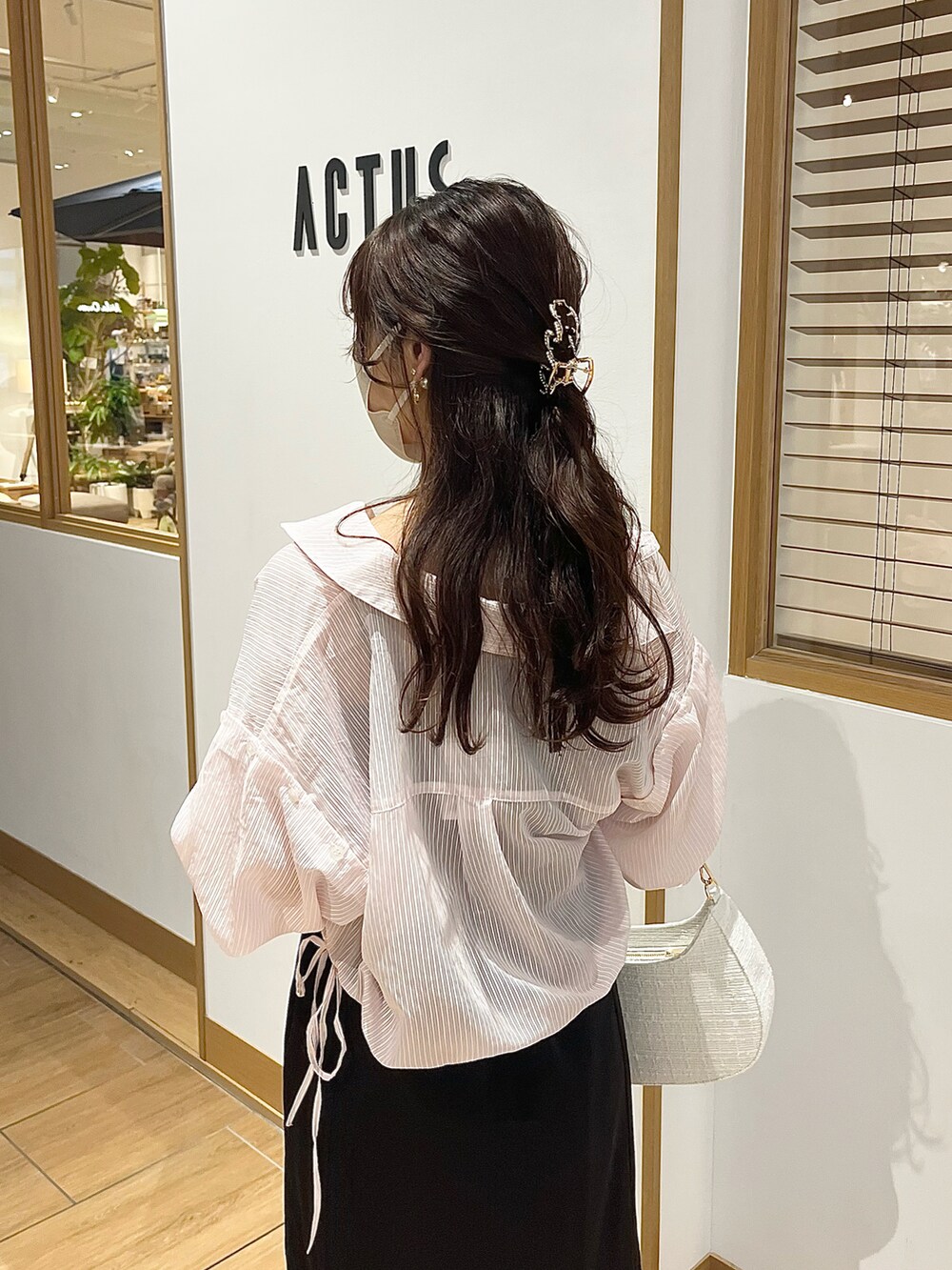 ブラック系のワンピース、ホワイト系のサンダル、ホワイト系のショルダーバッグを着用したレディースの春コーディネートの4枚目の写真