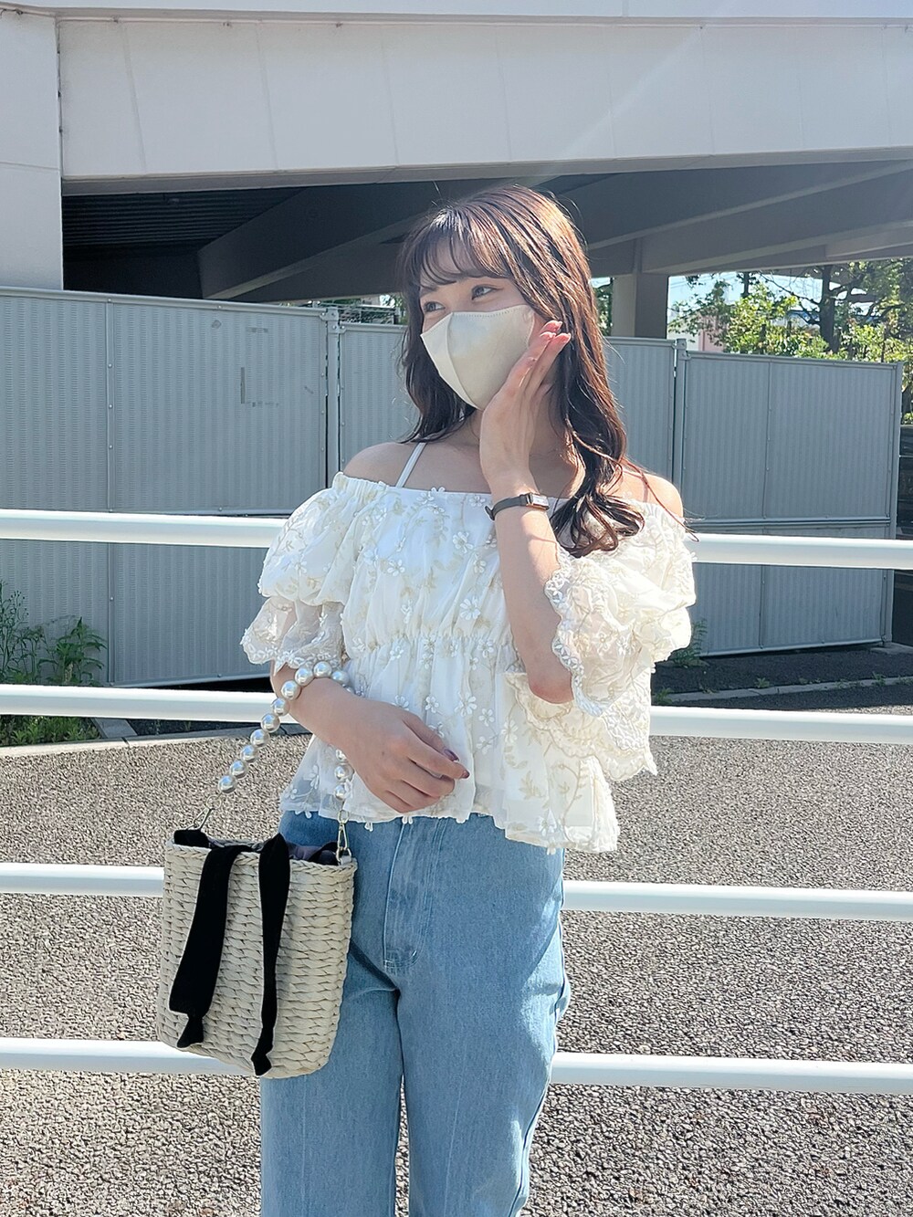 ブルー系のデニムパンツ、ブラック系のかごバッグ、ホワイト系のシャツ/ブラウスを着用したレディースの春コーディネートの2枚目の写真