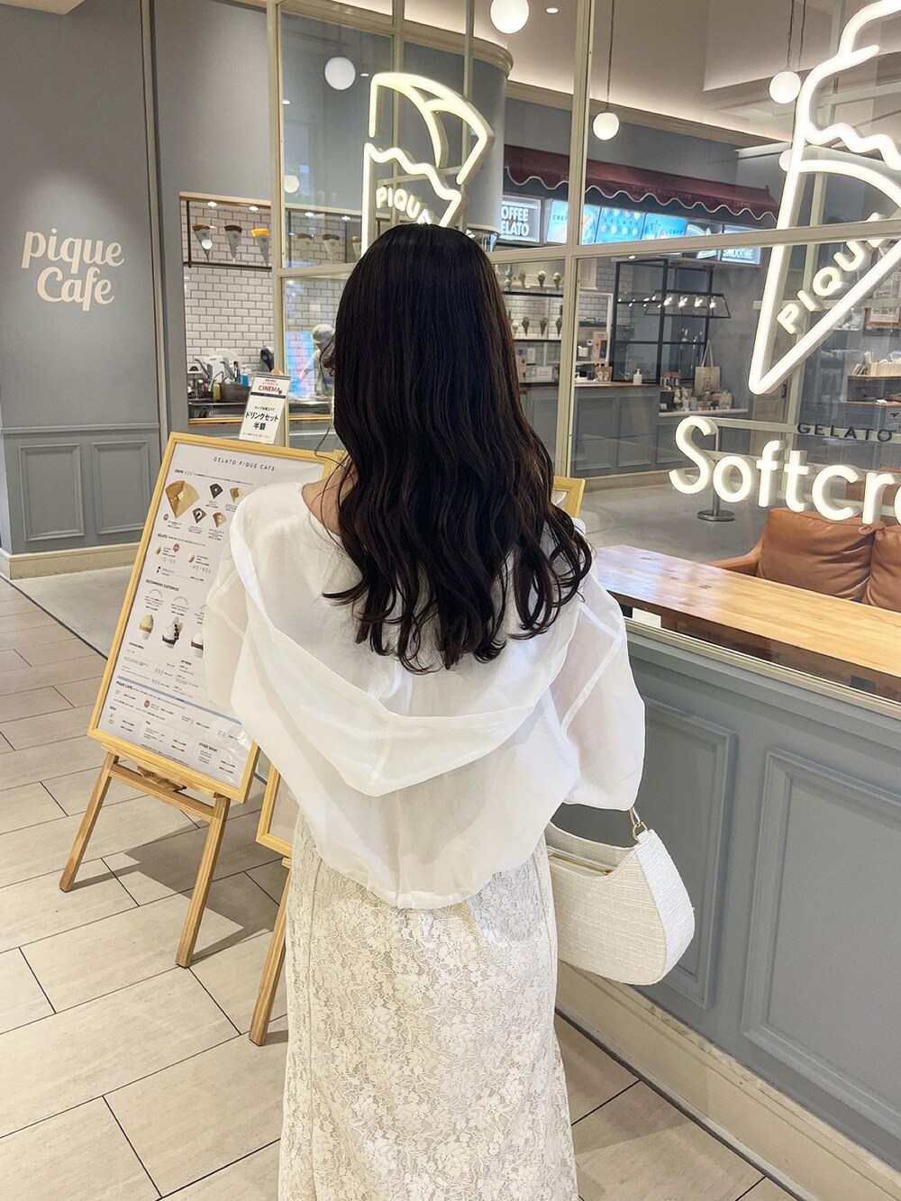 ホワイト系のワンピース、ホワイト系のショルダーバッグ、ホワイト系のマウンテンパーカーを着用したレディースの春コーディネートの2枚目の写真