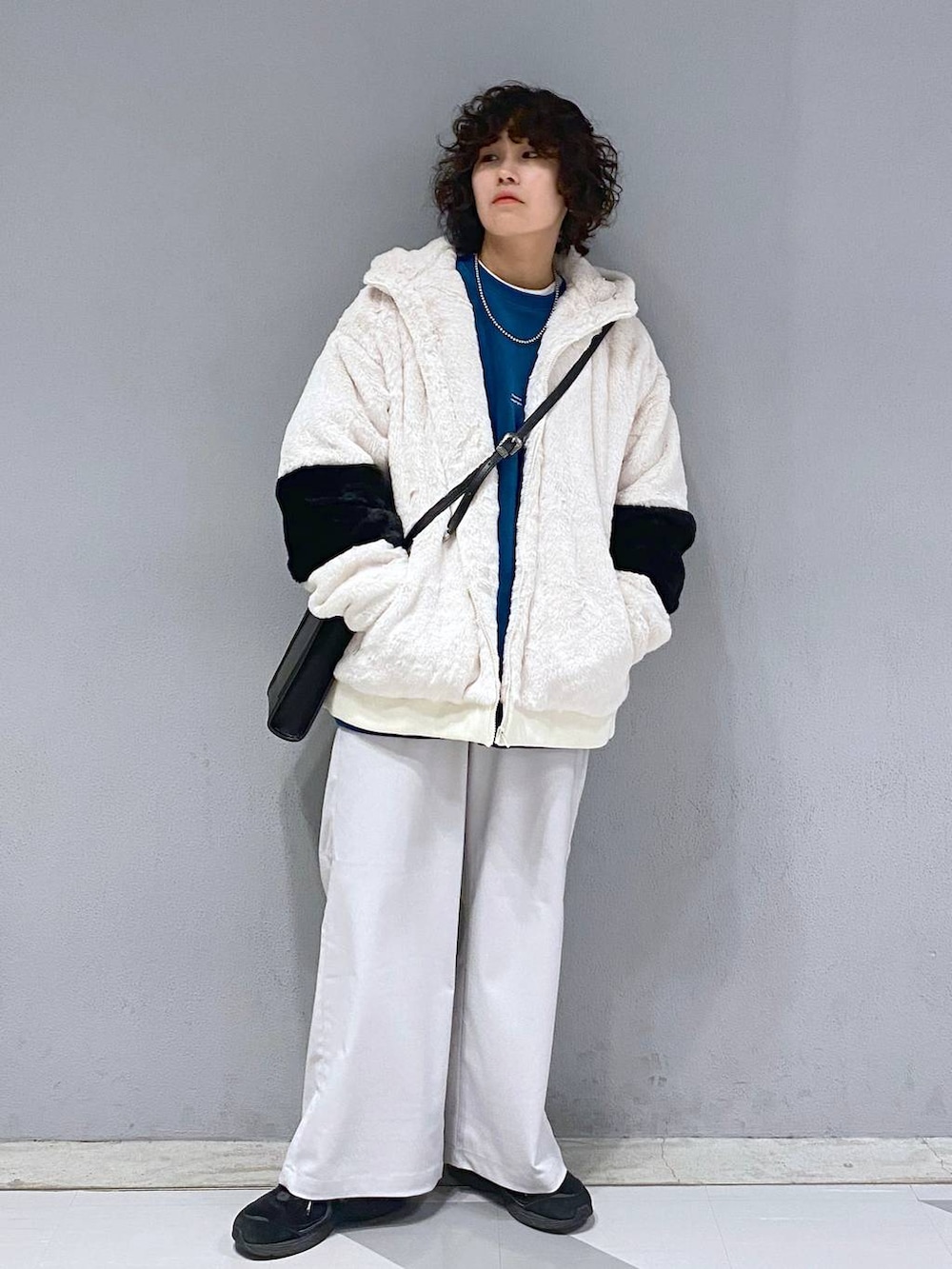 ブルー系のスウェット、ホワイト系のブルゾン、ブラック系のショルダーバッグを着用したメンズの冬コーディネートの2枚目の写真