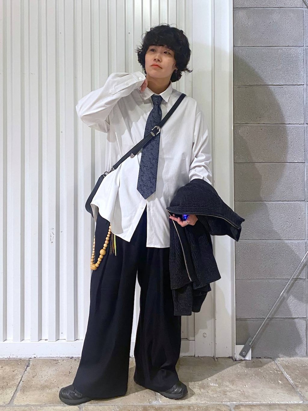 ブラック系のスニーカー、ブラック系のニット/セーター、ブラック系のショルダーバッグを着用したメンズの秋コーディネートの4枚目の写真