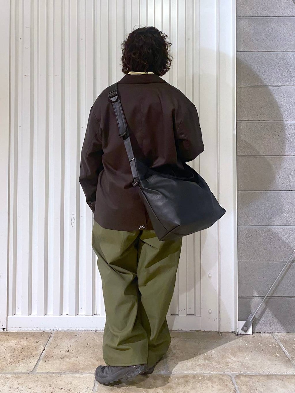 ブラック系のショルダーバッグ、ブラック系のスニーカー、ブラウン系のテーラードジャケットを着用したメンズの秋コーディネートの7枚目の写真